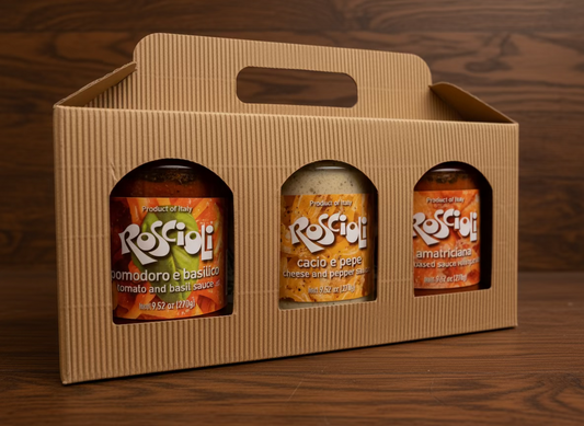 Three jars of Roscioli sauce in a cardboard carrier on a wooden surface.