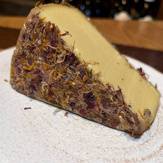 Triangle of cheese with dried flowers on a plate