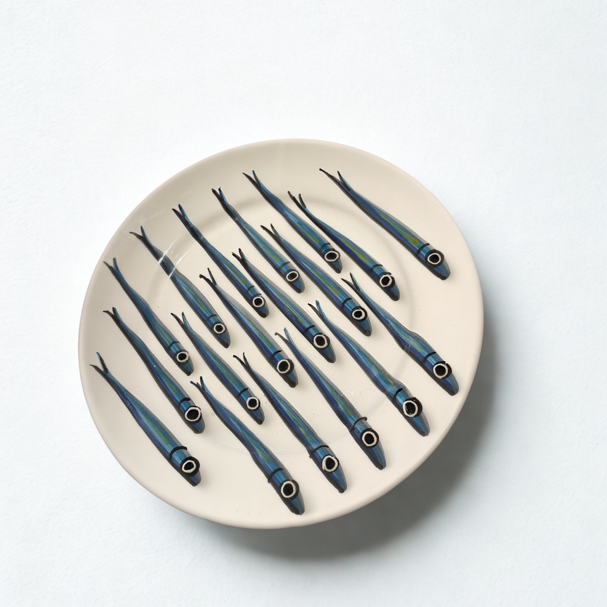 Round ceramic plate with blue fish design on a white background